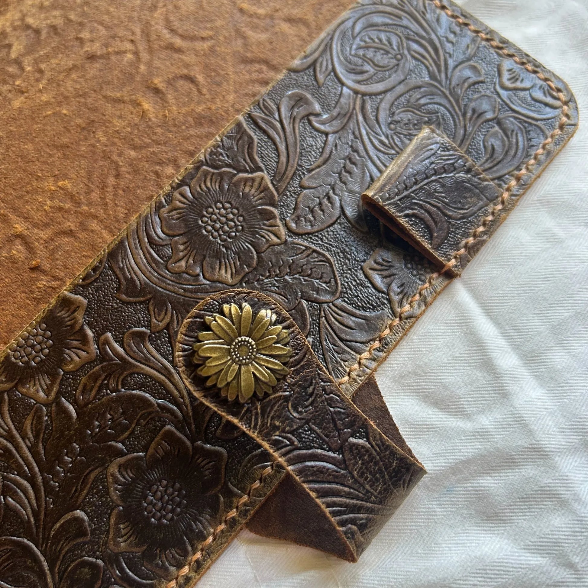 Hand holding leather Bible cover with stitching detail