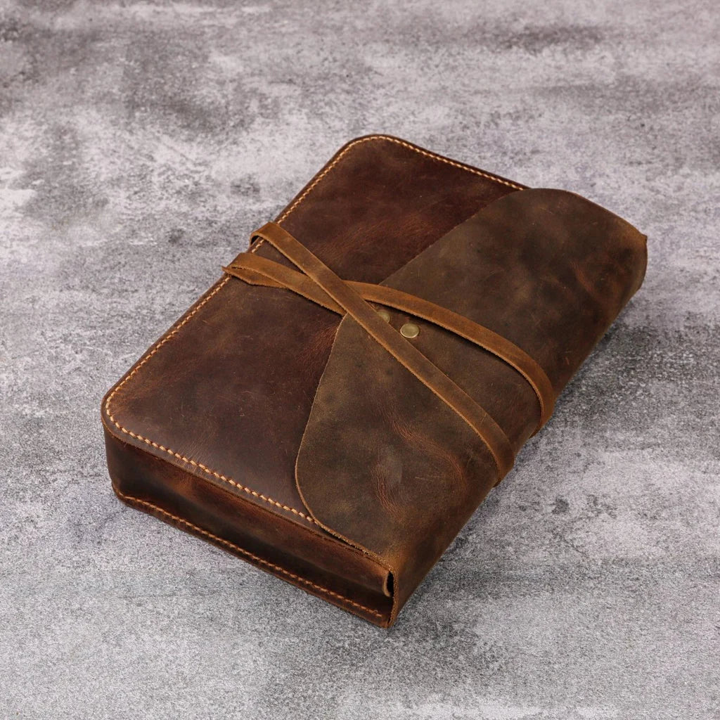 Rustic full-grain leather Bible cover, completely closed and secured with a wrap-around leather strap.