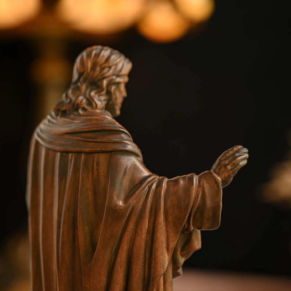Back angle view of a 3D carved beechwood Jesus statue showing detailed robe and shoulder carving