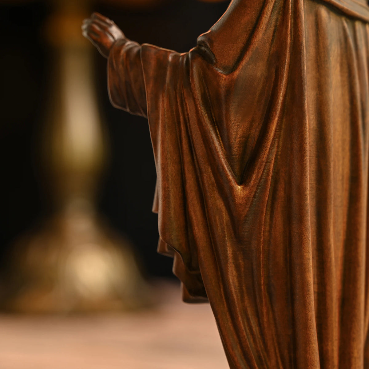 Close-up of a 3D carved beechwood Jesus statue showing detailed robe carving and wood texture