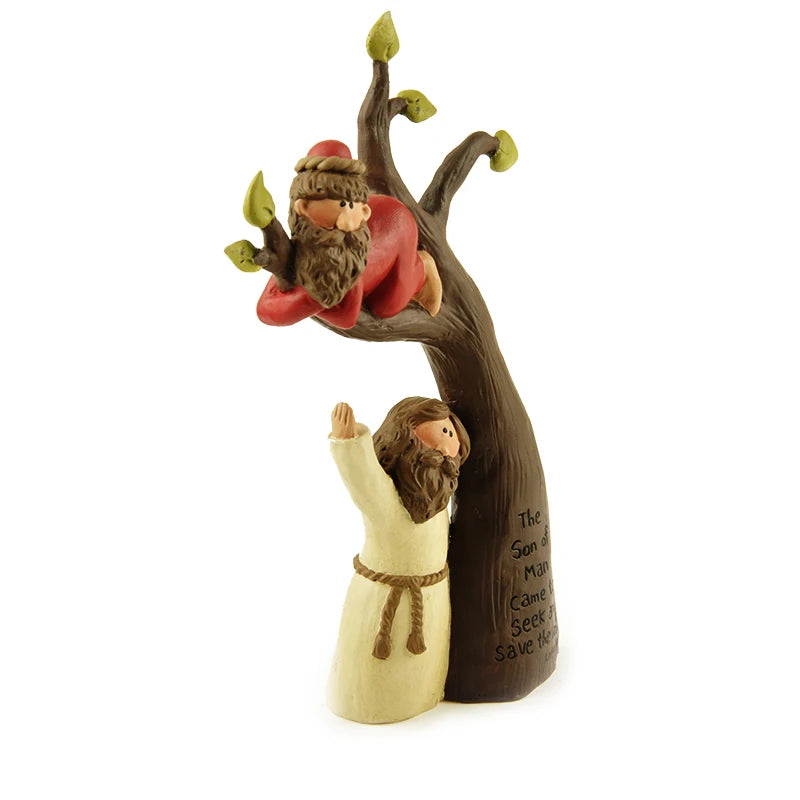 Side view of the resin sculpture depicting Zacchaeus in the sycamore tree, with a standing figure reaching up. The scripture "The Son of Man Came to Seek and Save the lost. Luke 19:10" is visible on the tree trunk.