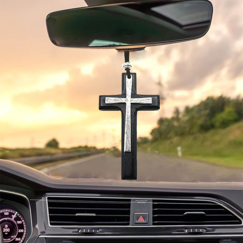 Black wood cross necklace with silver metal overlay hanging inside car