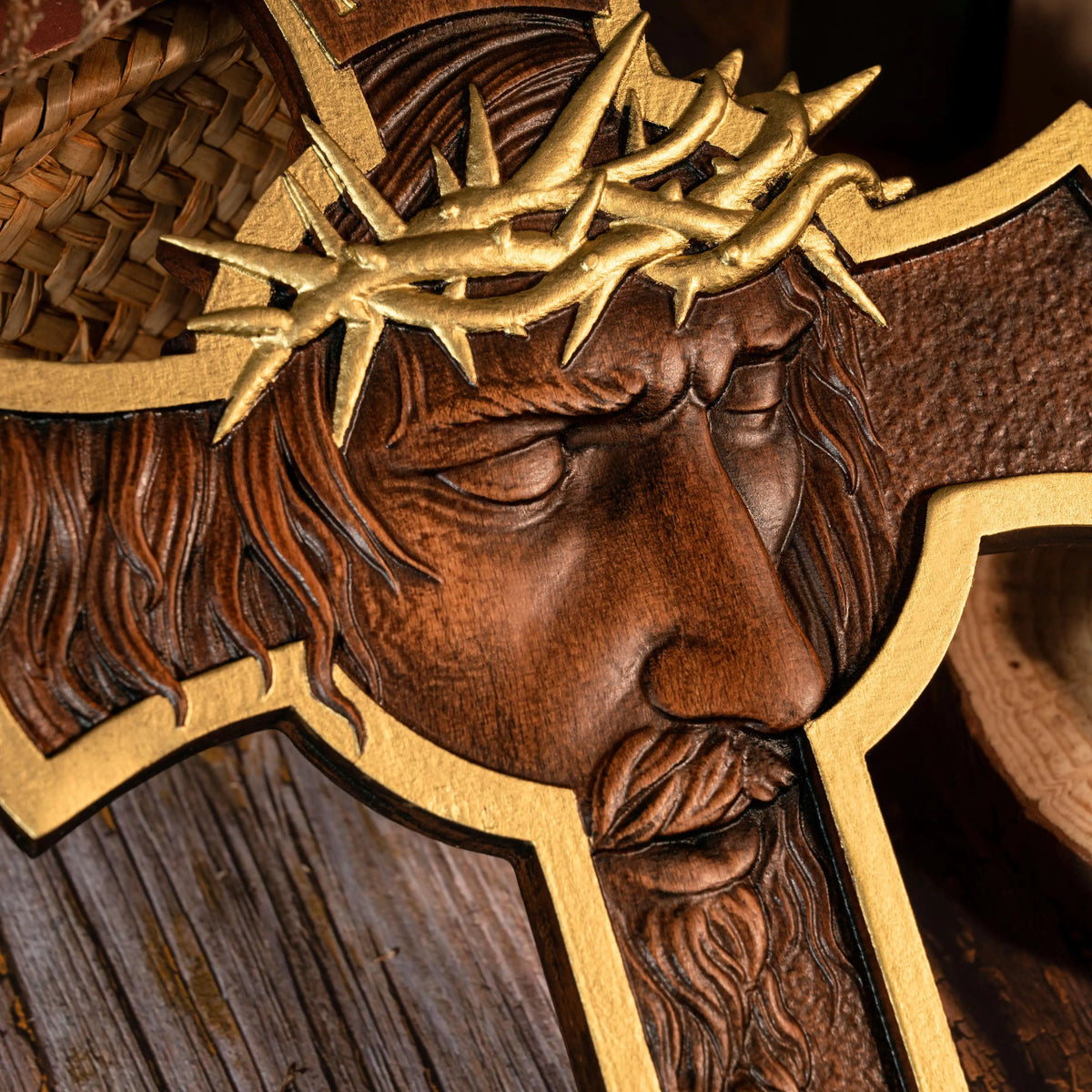 Close-up of a gold-accented wooden Jesus crucifix showing detailed face carving and crown of thorns
