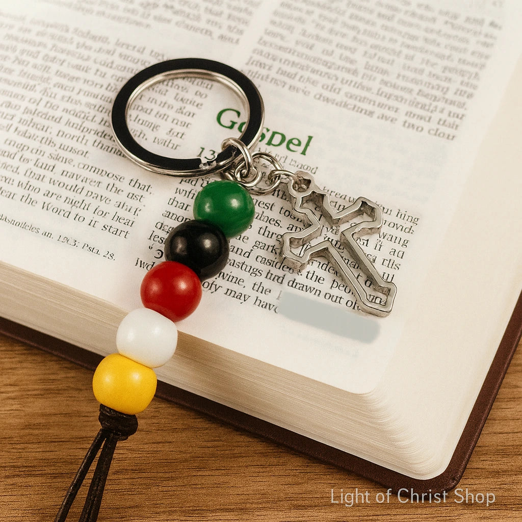 Five-color Gospel Beads Keychain resting on open Bible pages, highlighting its religious significance.