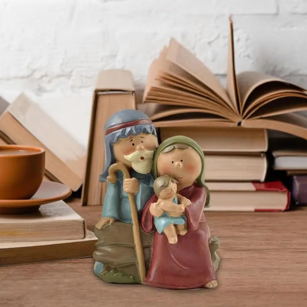 Holy Family Nativity figurine displayed on a table with books, featuring Mary, Joseph, and Baby Jesus in a cute resin design