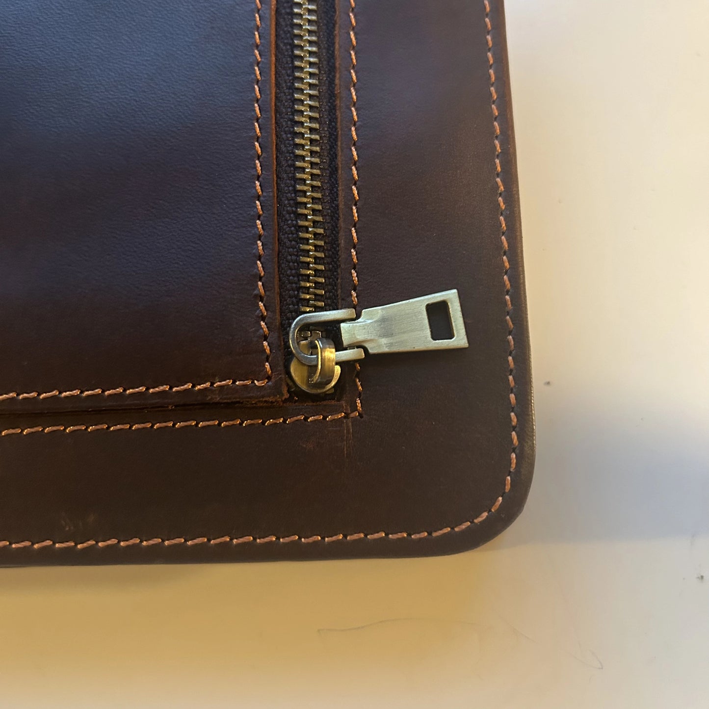 Close-up view of the zipper and stitching on the genuine leather Bible cover, handcrafted in brown leather.