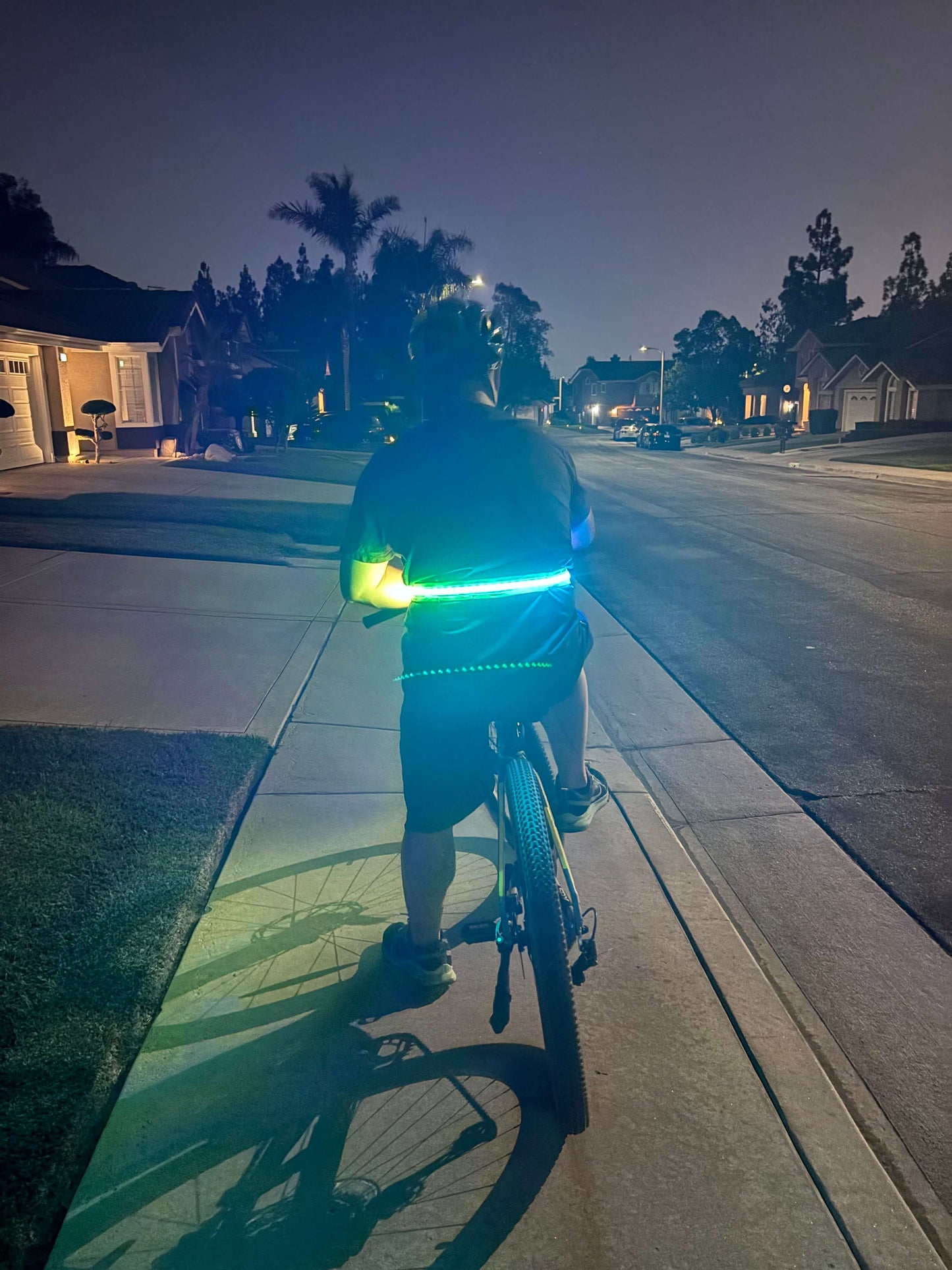 Cyclist wearing an LED safety strip around the waist for increased visibility while riding at night