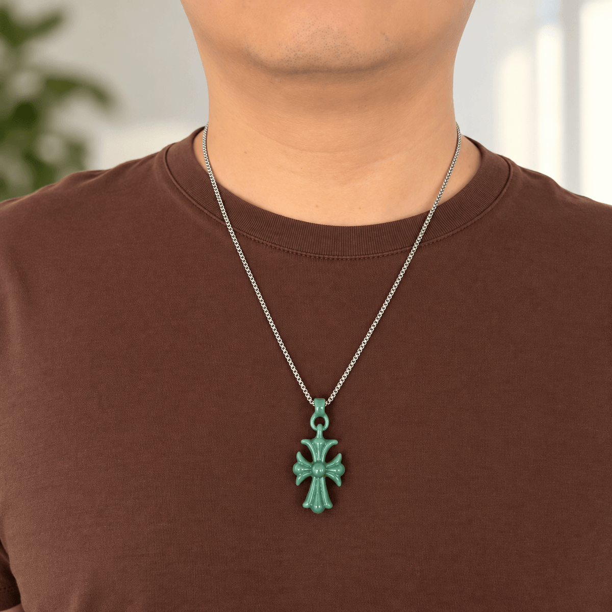 Natural Grade A bean green jadeite cross pendant worn by a man with a silver-toned chain
