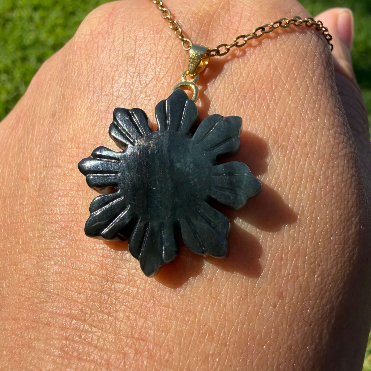 Front view of a polished natural untreated Wuji jadeite Filipino Sunflower pendant with carved petals