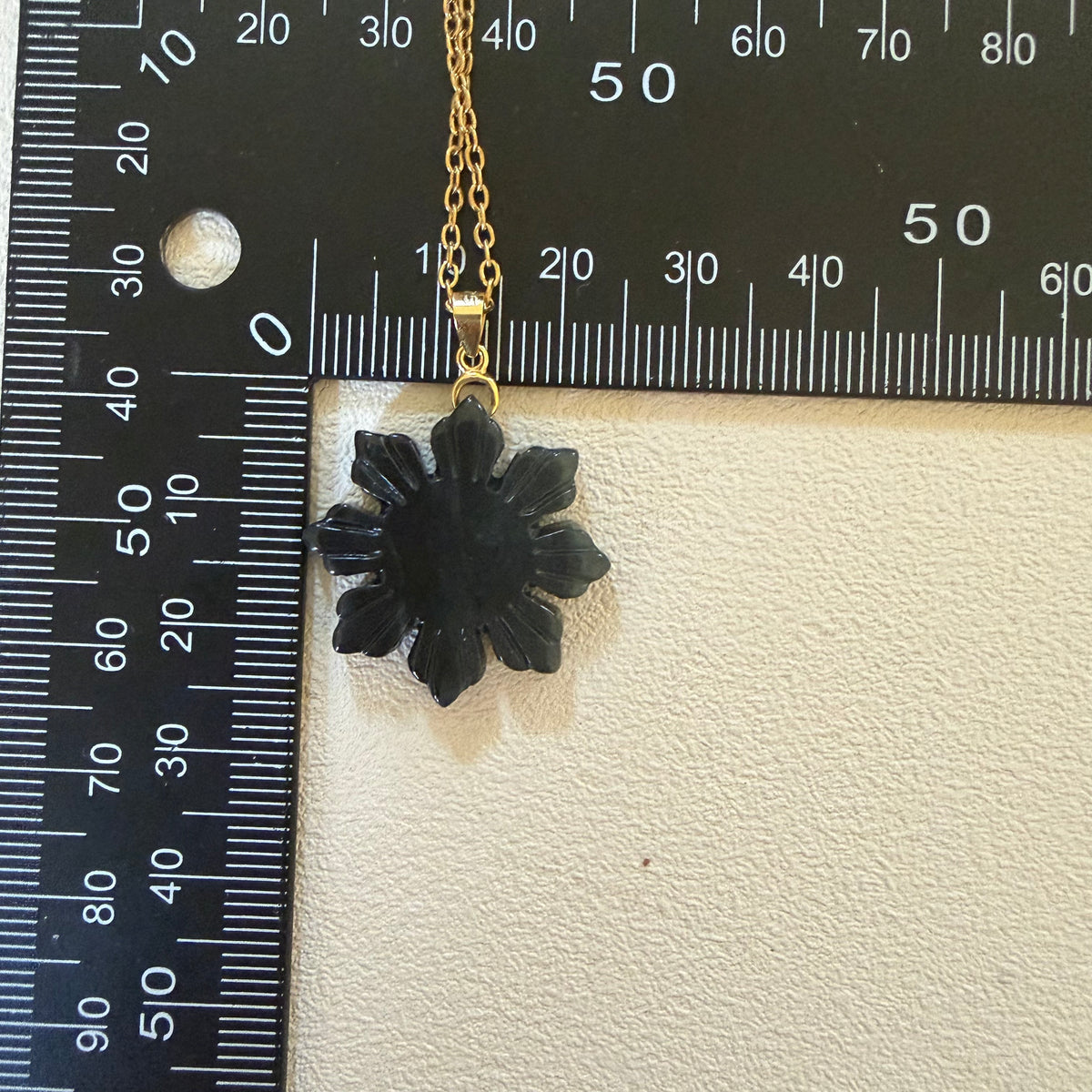 Natural untreated Wuji jadeite Filipino Sunflower pendant beside a measuring ruler to illustrate its size