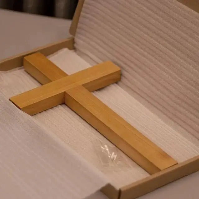 Solid cherry wood cross placed inside protective packaging in a cardboard box